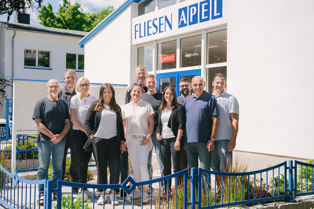 Das Team vom Fliesenhandel Apel steht bei sommerlichen Wetter vor der Ausstellung.