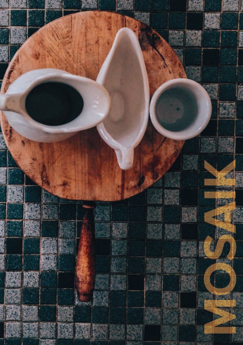 Holzbrett mit Saucieren und Tasse auf gefliester Fläche; Text „MOSAIK“.
