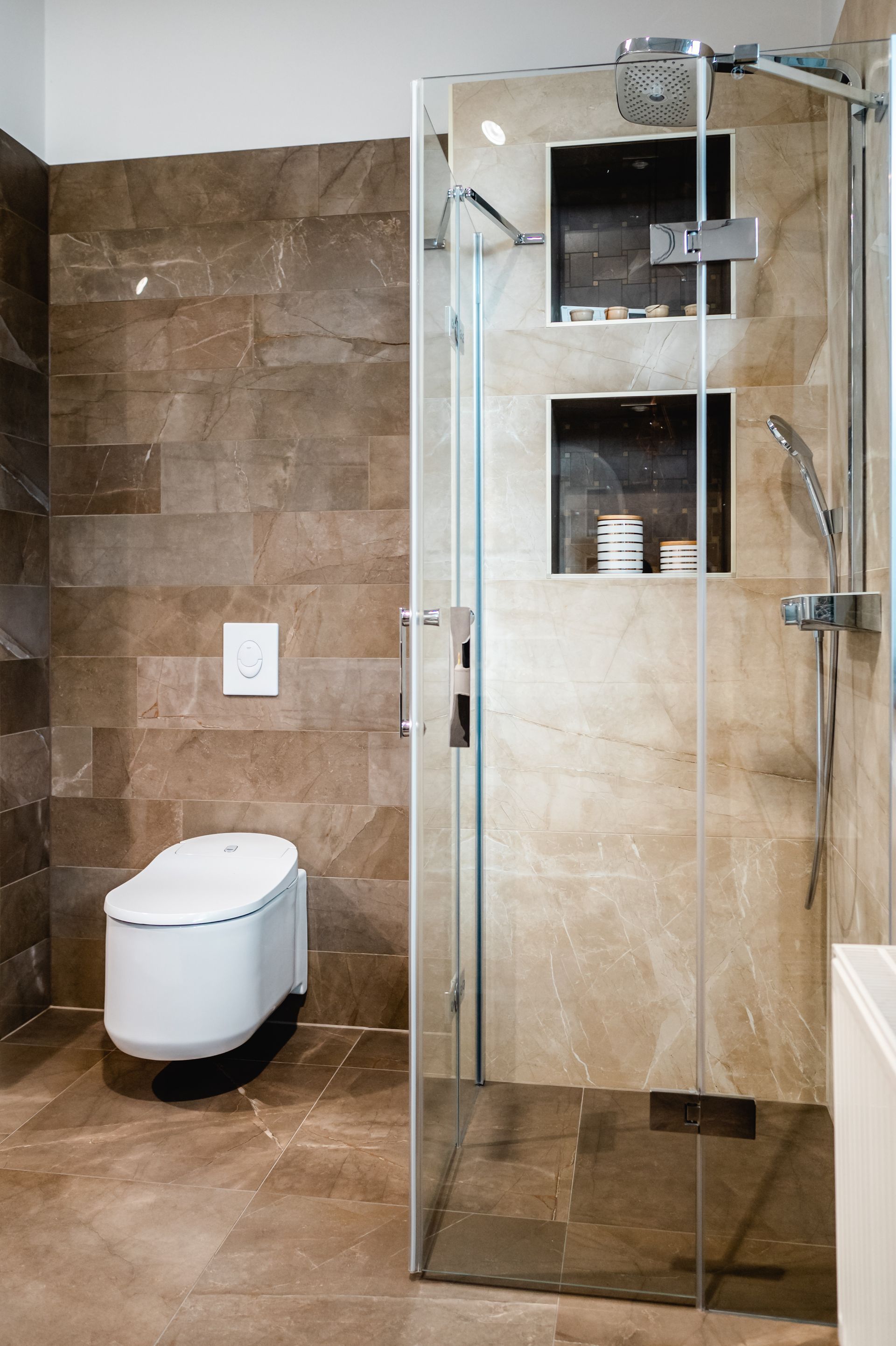 Modernes Badezimmer mit Steinwänden, wandmontiertem WC und verglaster Dusche.