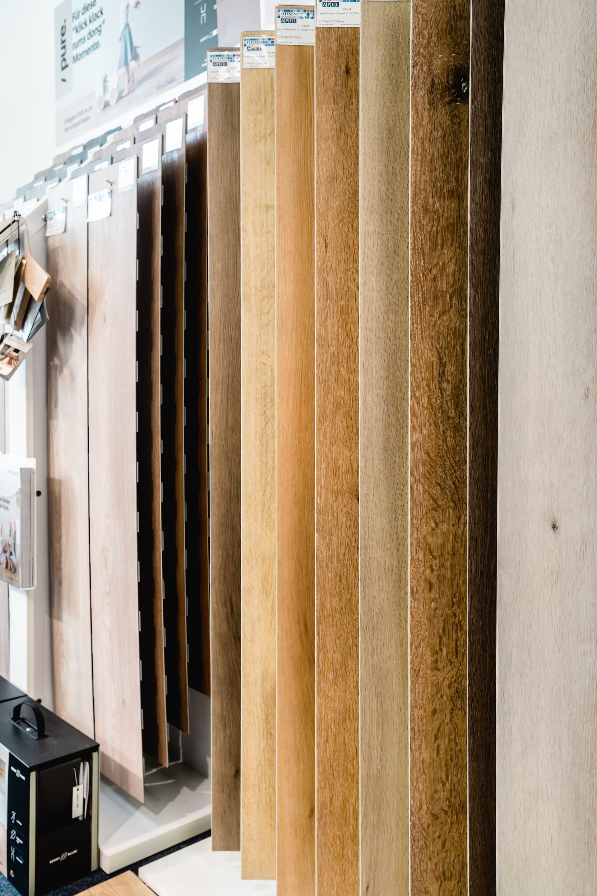 Ausstellung vertikaler Bodenbelagsmuster in verschiedenen Braun- und Beigetönen.