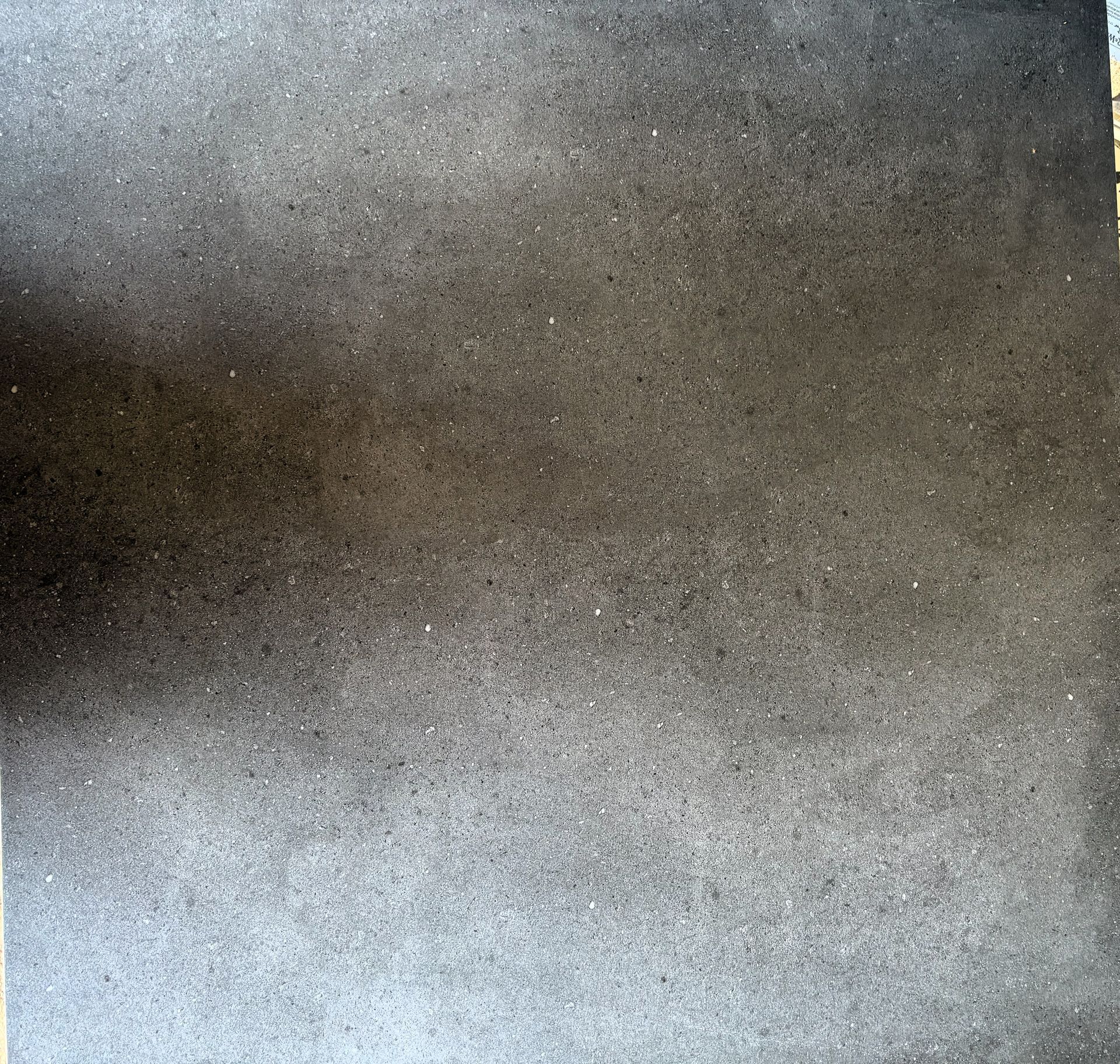 Dunkelgraue, strukturierte Oberfläche, möglicherweise Beton oder Stein, mit subtilen Farbvariationen.