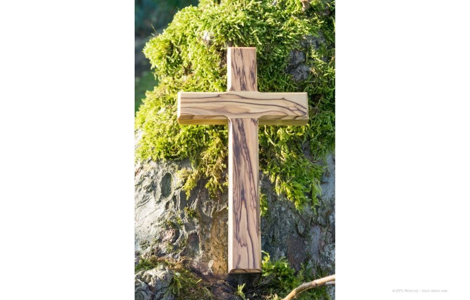 Statue einer weinenden Frau vor einer Kirche mit Kuppelturm, umgeben von Rosen.