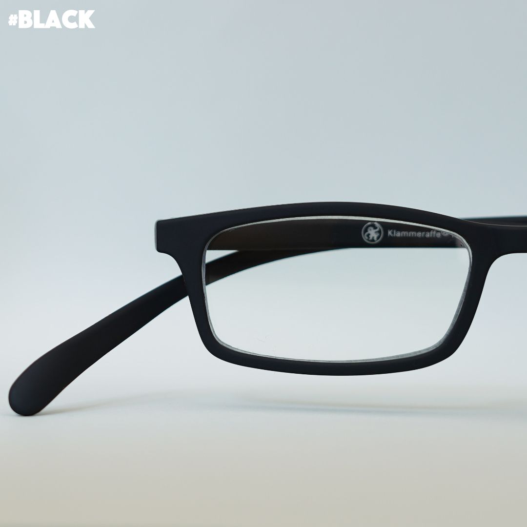 Schwarze Korrektionsbrille auf grauem Hintergrund.