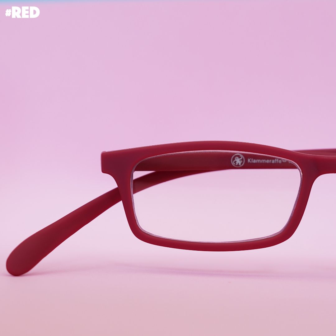 Rote Korrektionsbrille auf rotem Hintergrund.
