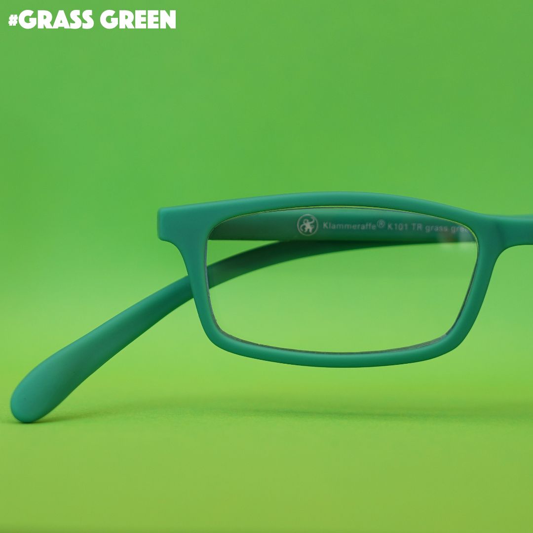 Grüne Korrektionsbrille auf grünem Hintergrund.