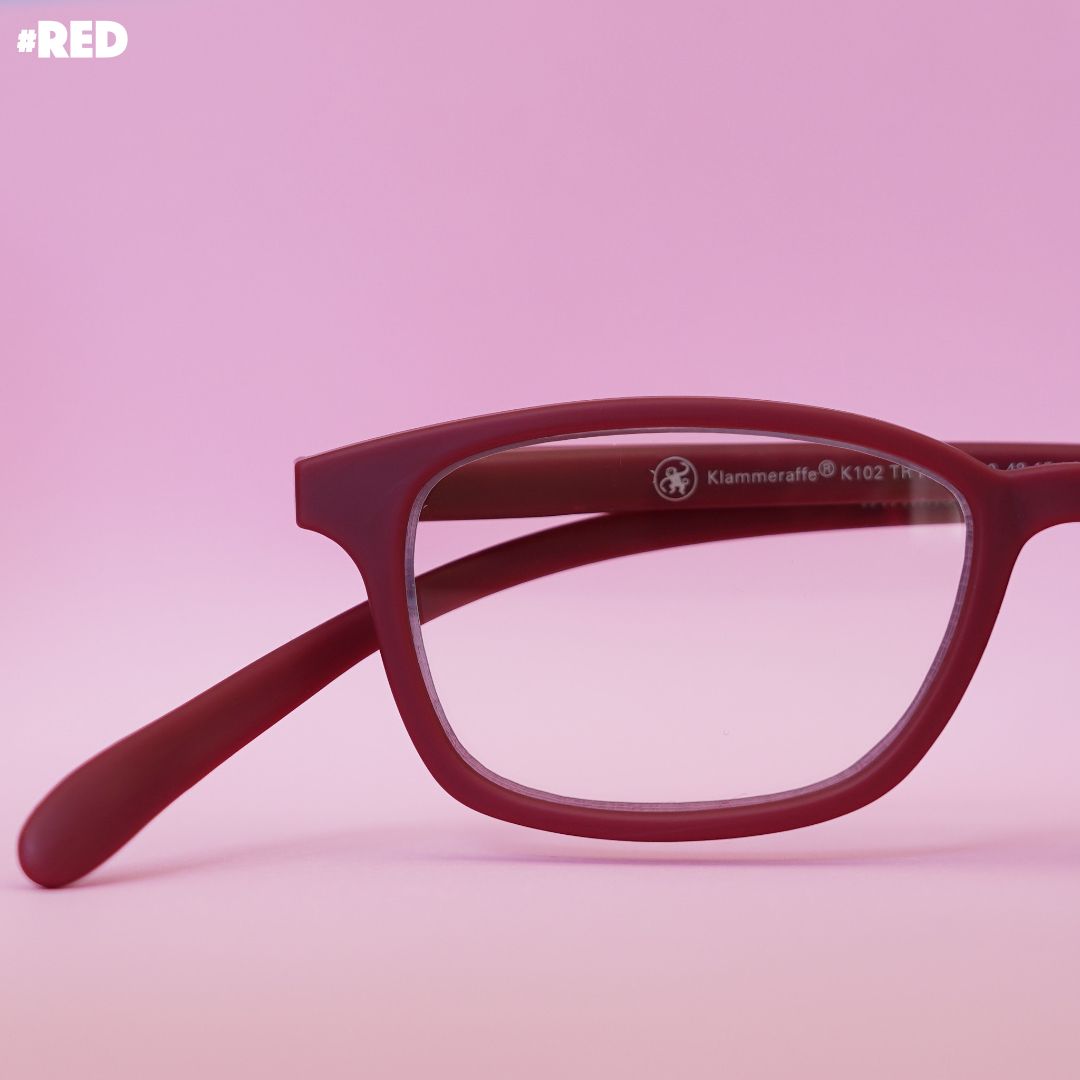 Rote Korrektionsbrille auf rotem Hintergrund.