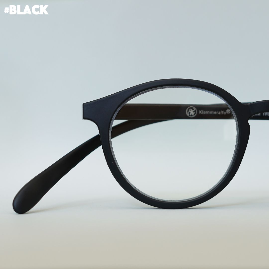 Schwarze Korrektionsbrille auf grauem Hintergrund.