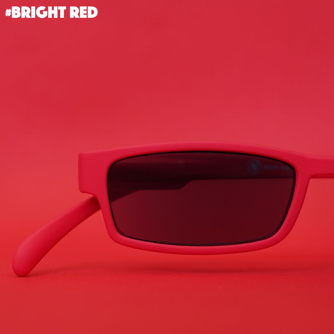 Eine knallrote Sonnenlesebrille auf rotem Hintergrund