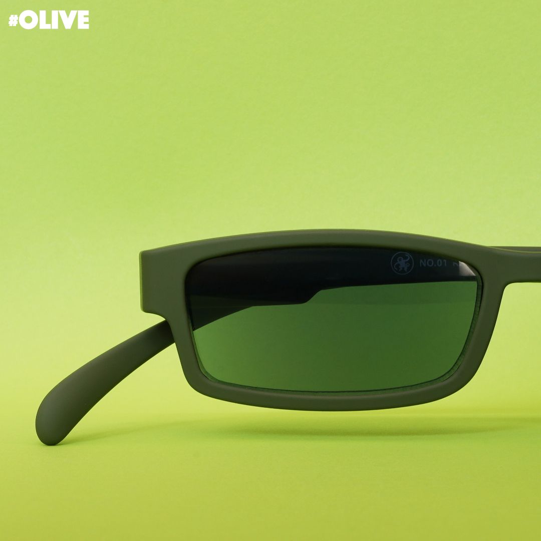 Eine olive farbene Sonnenlesebrille auf grünem Hintergrund