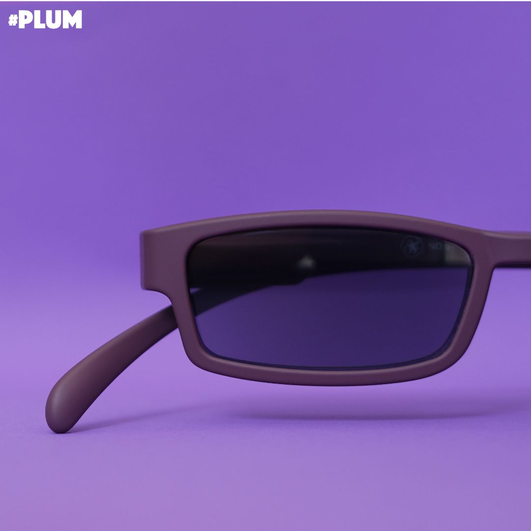 Eine pflaumen farbene  Sonnenlesebrille auf lilanem Hintergrund