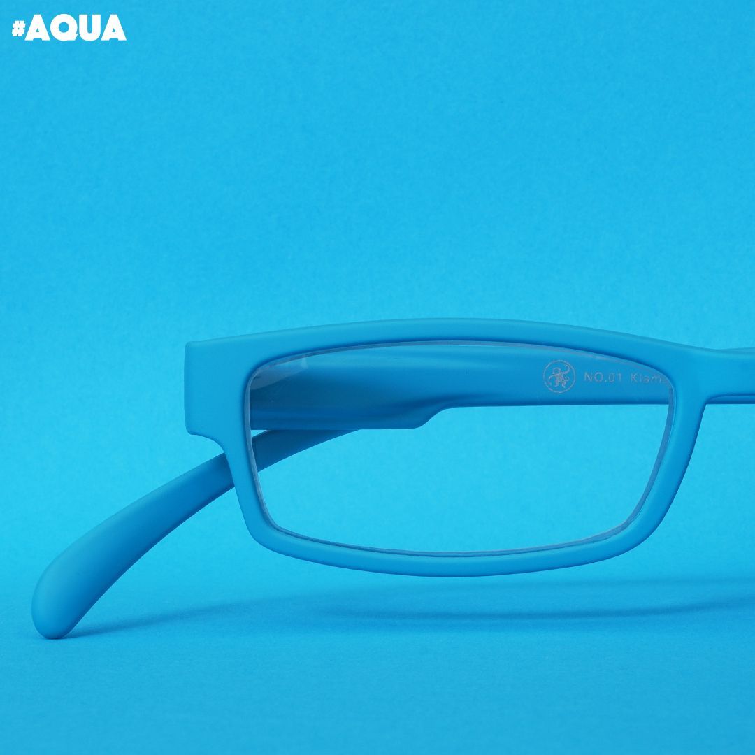 Eine aqua farbene Lesebrille auf blauem Hintergrund.