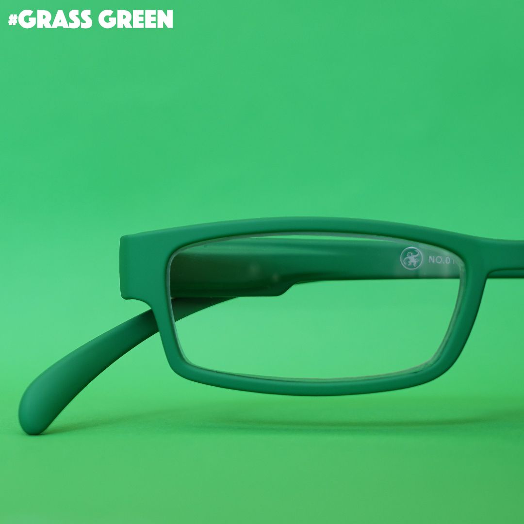 Eine grass grün farbene  Lesebrille auf grünem Hintergrund.