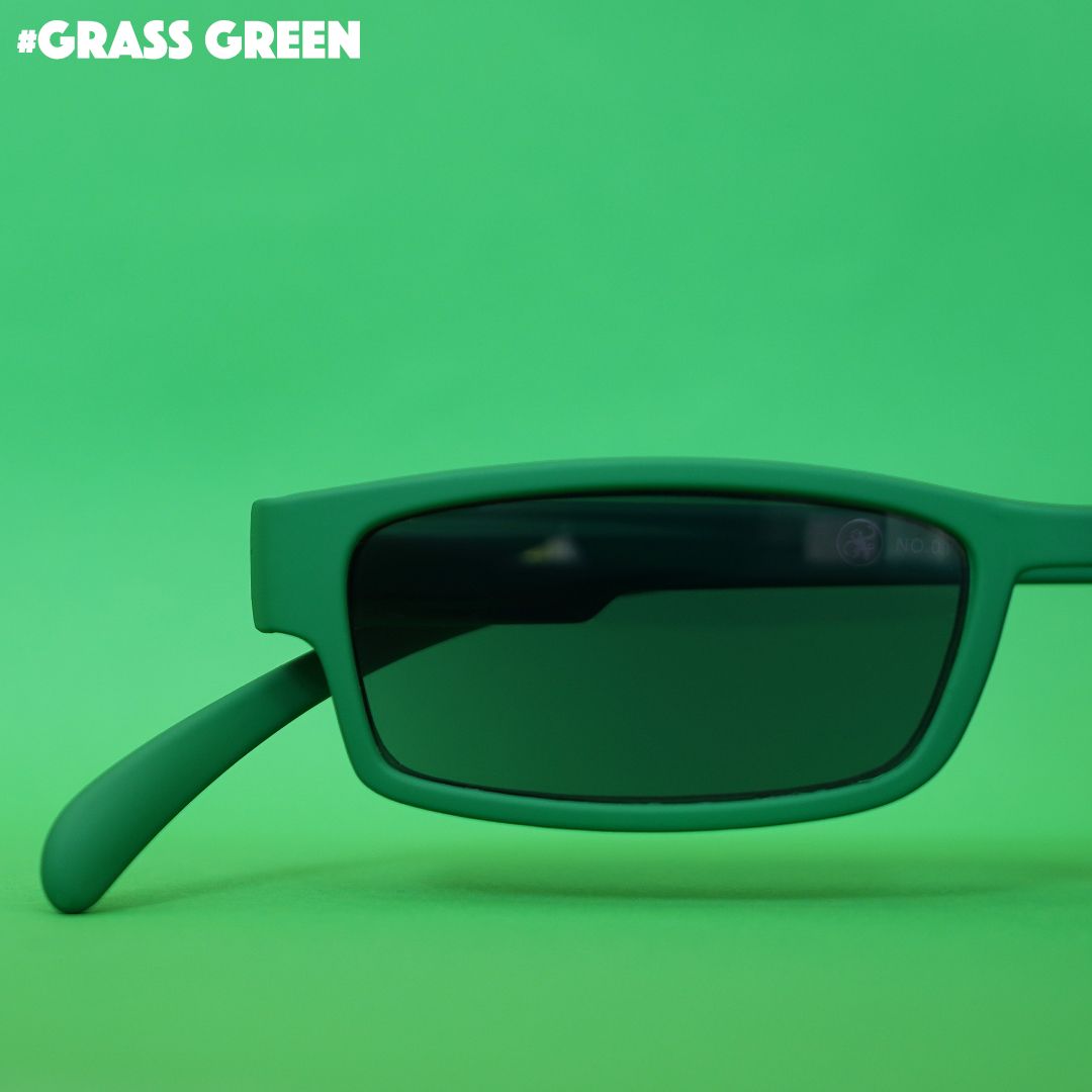 Eine grass grüne Sonnenlesebrille auf grünem Hintergrund