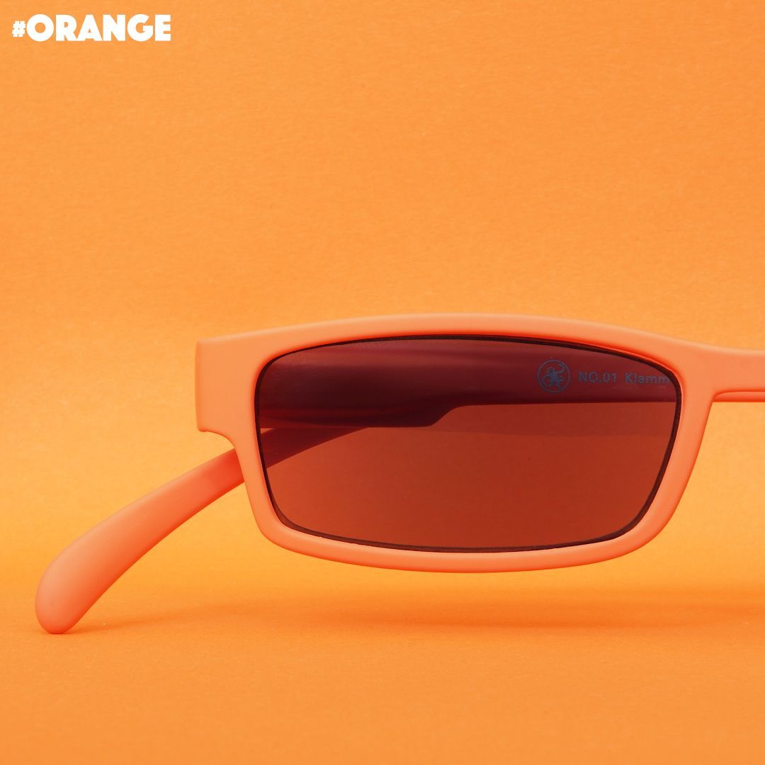 Eine orangene Sonnenlesebrille auf orangenem Hintergrund