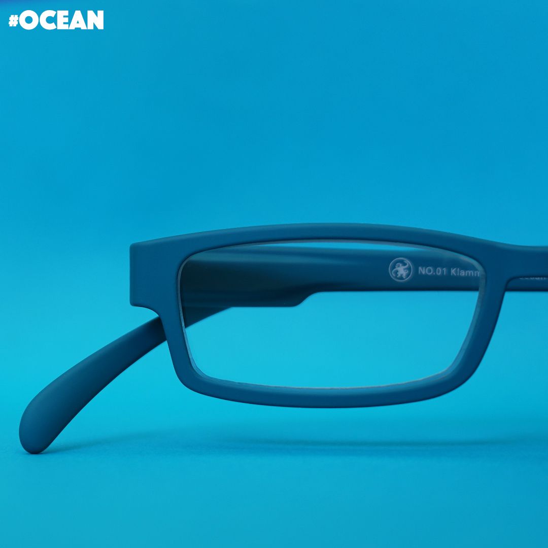 Eine Ozean farbene Lesebrille auf blauem Hintergrund.