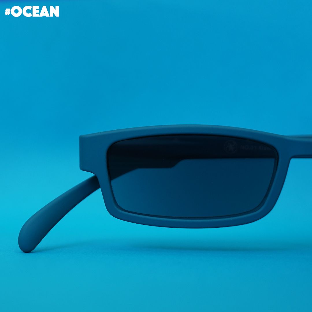 Eine Ozean farbene Sonnenlesebrille auf blauem Hintergrund