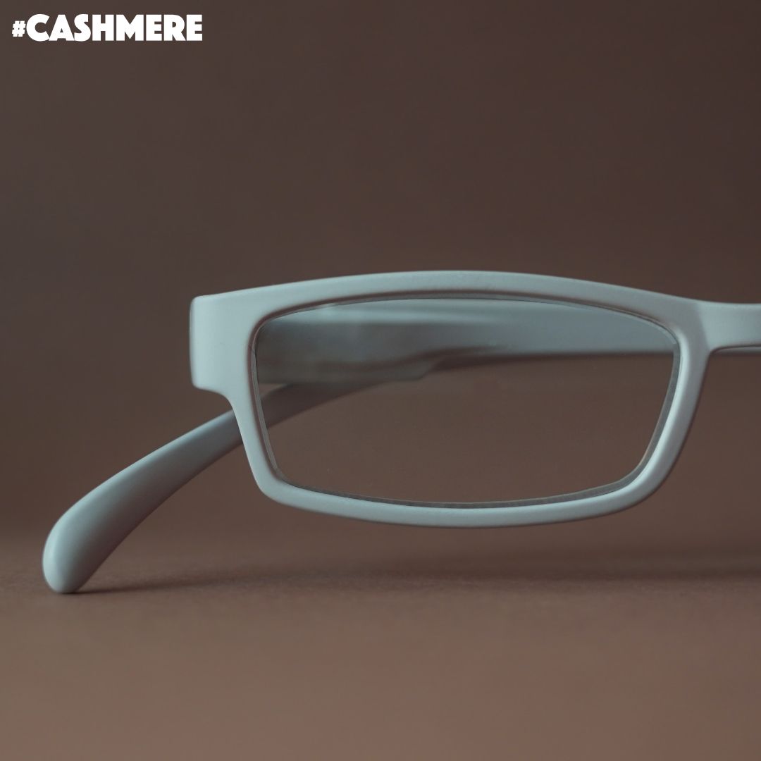 Eine cashmere farbene Lesebrille auf braunem Hintergrund.