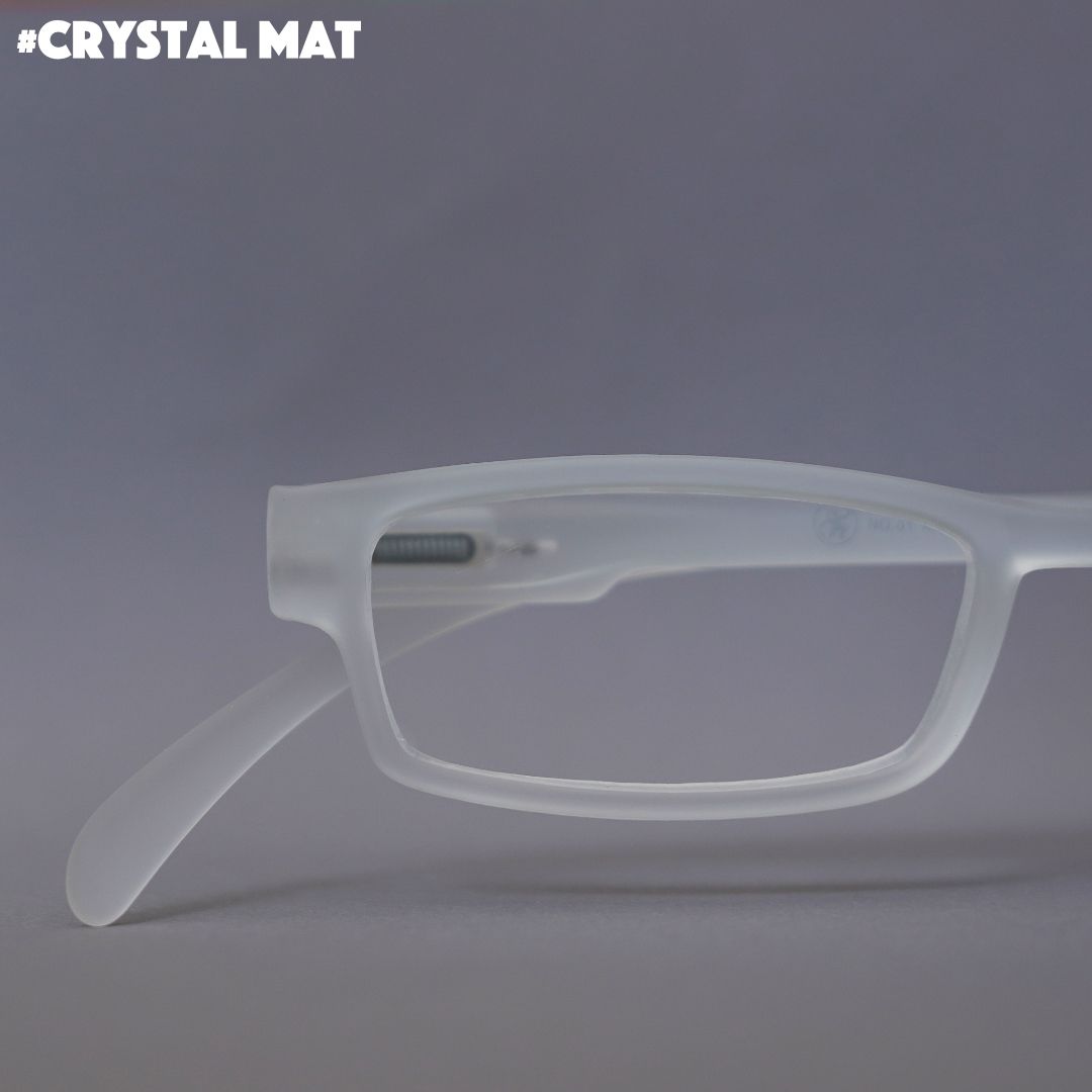 Eine kristall durchscheinende Lesebrille auf hellgrauem Hintergrund.