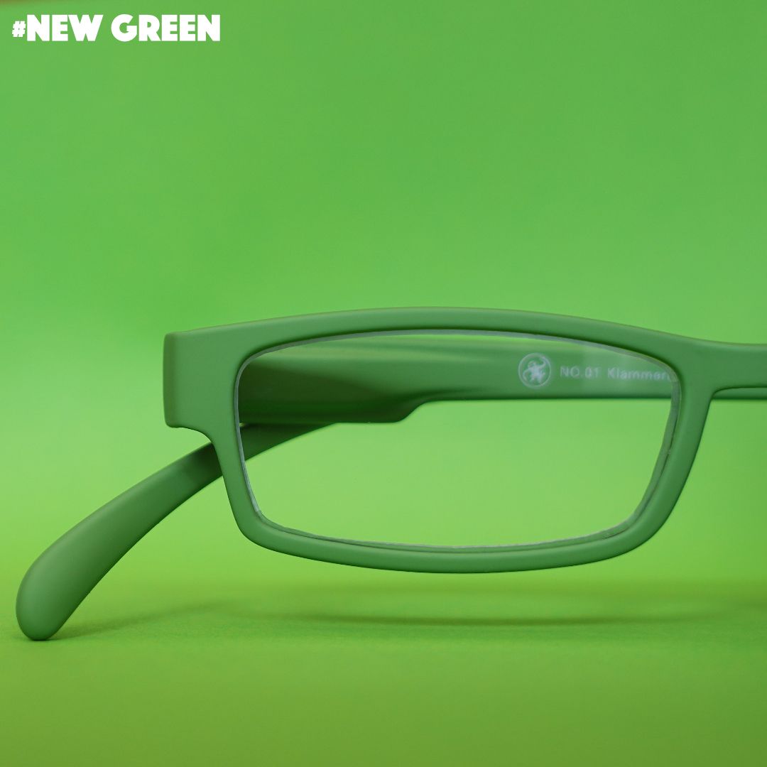 Eine grüne Lesebrille auf grünem Hintergrund.