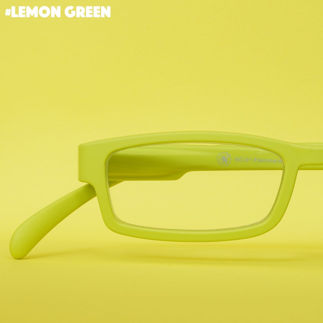 Eine Limonen farbene Lesebrille auf Limonen farbenem Hintergrund.