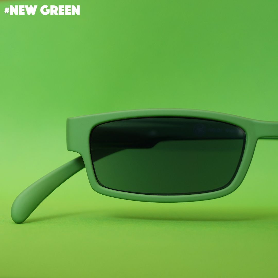 Eine grüne Sonnenlesebrille auf grünem Hintergrund