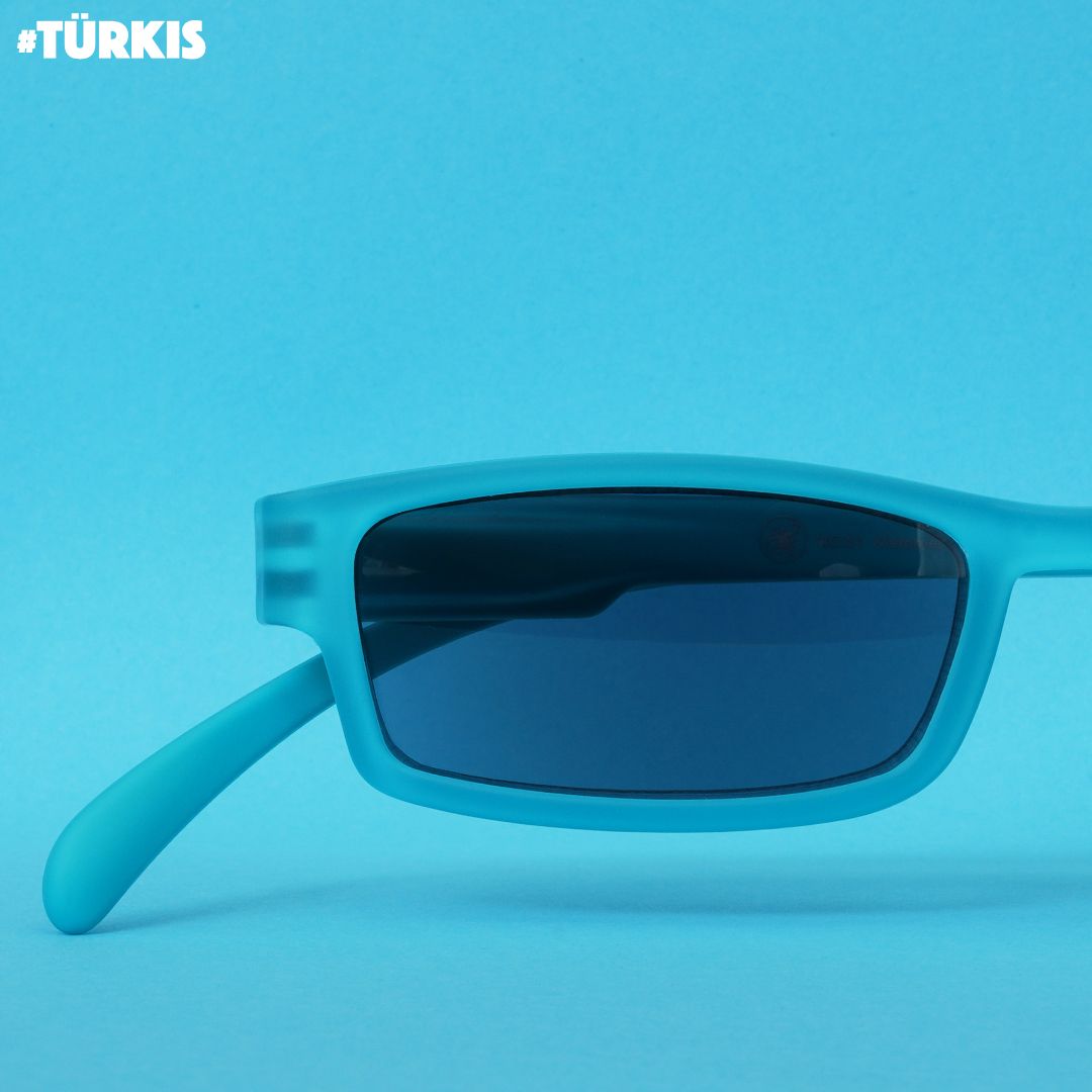 Eine türkise Sonnenlesebrille auf Türkisen Hintergrund