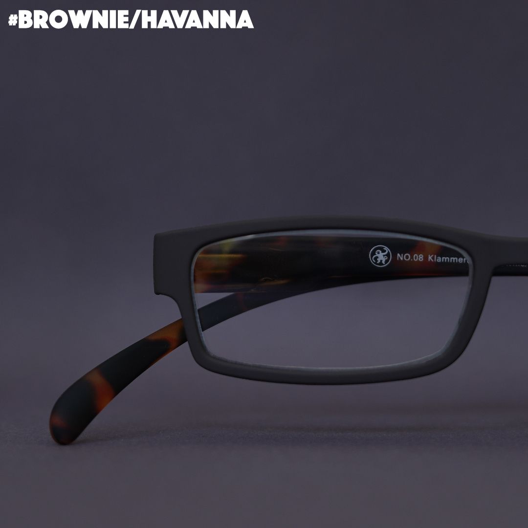 Eine braune Lesebrille mit Bügeln im  Havanna Look auf braunem Hintergrund.