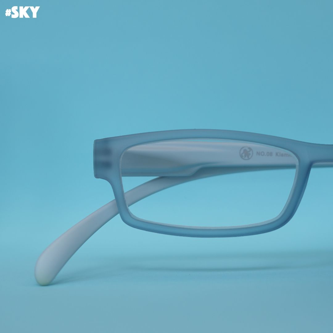 Eine Lesebrille mit blau transparenter Front und hellblauen Bügeln auf blauem Hintergrund.