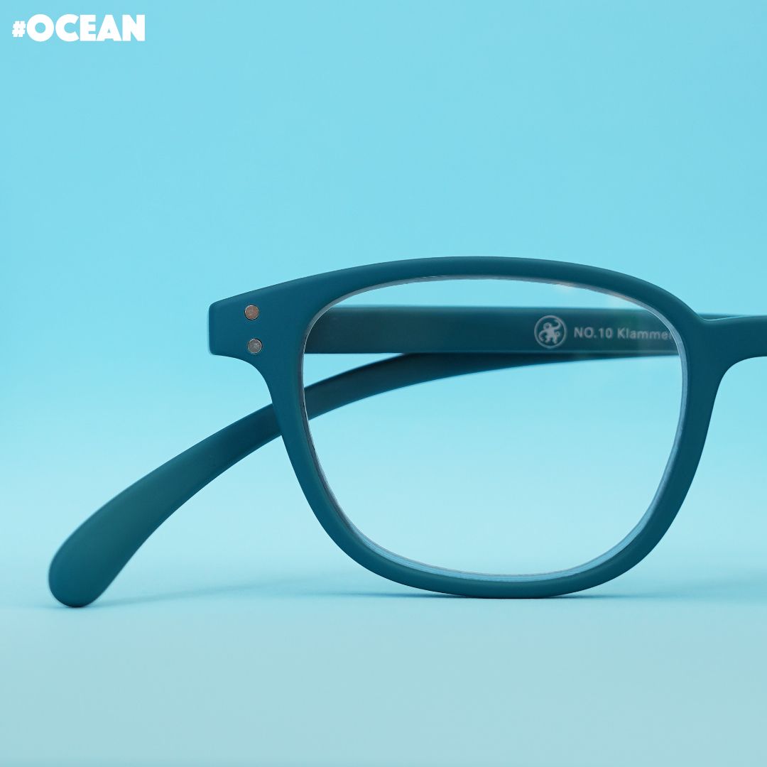 Eine Ozean farbene Brille  auf blauem Untergrund.