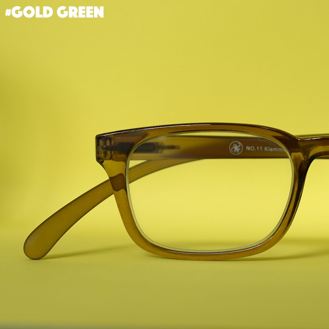 Eine grün transparente Lesebrille auf grünem Hintergrund.