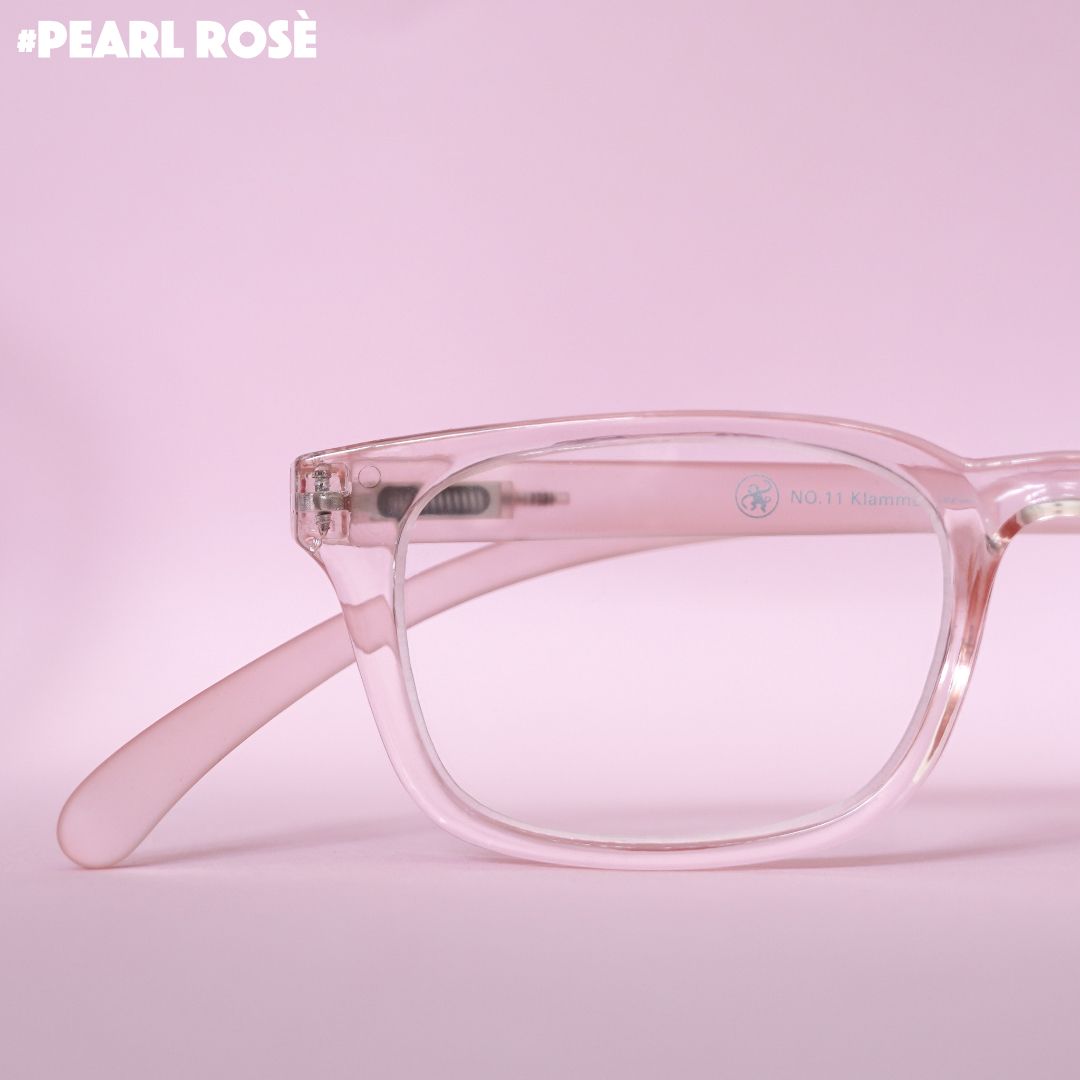 Eine rosé transparente Lesebrille auf pinkem Hintergrund.
