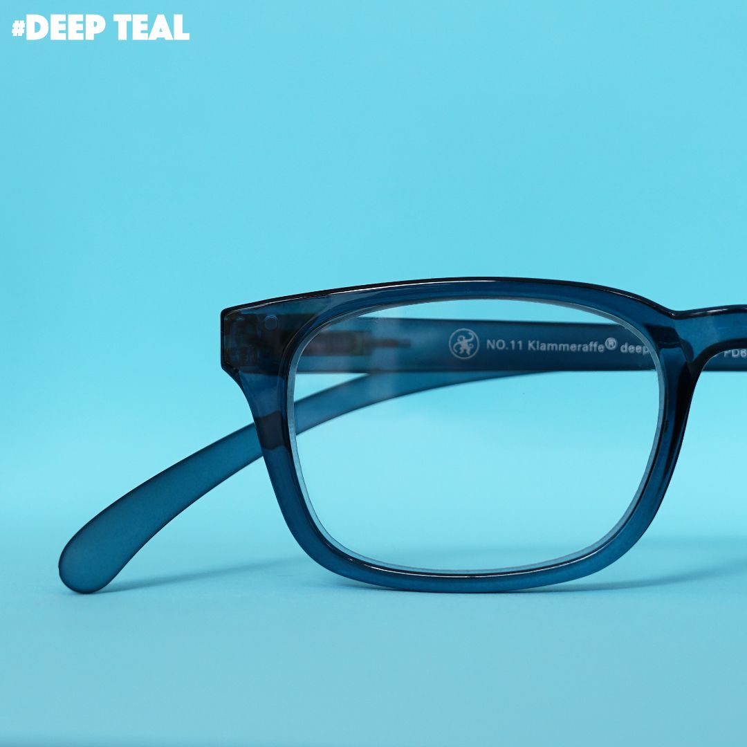 Eine blau transparente Lesebrille auf blauem Hintergrund.