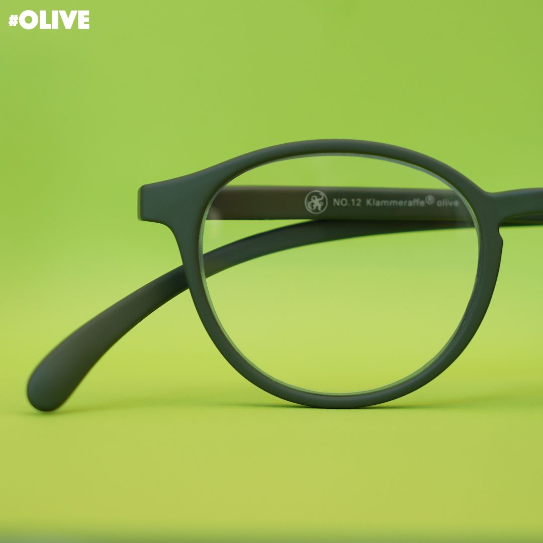 Eine olive farbene Brille auf grünem Hintergrund.