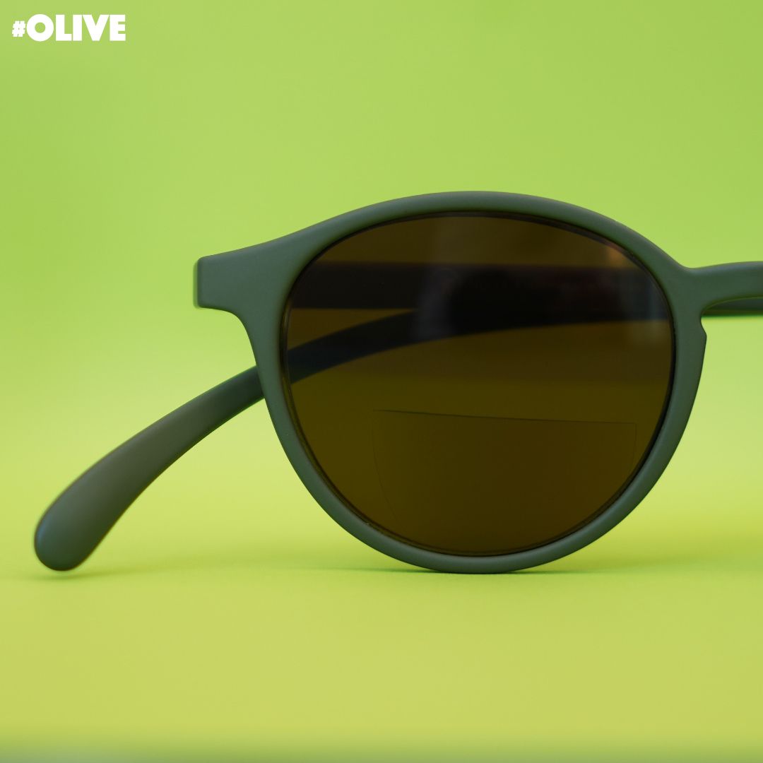 Eine olive farbene Bifokal-Sonnenbrille auf grünem Hintergrund.