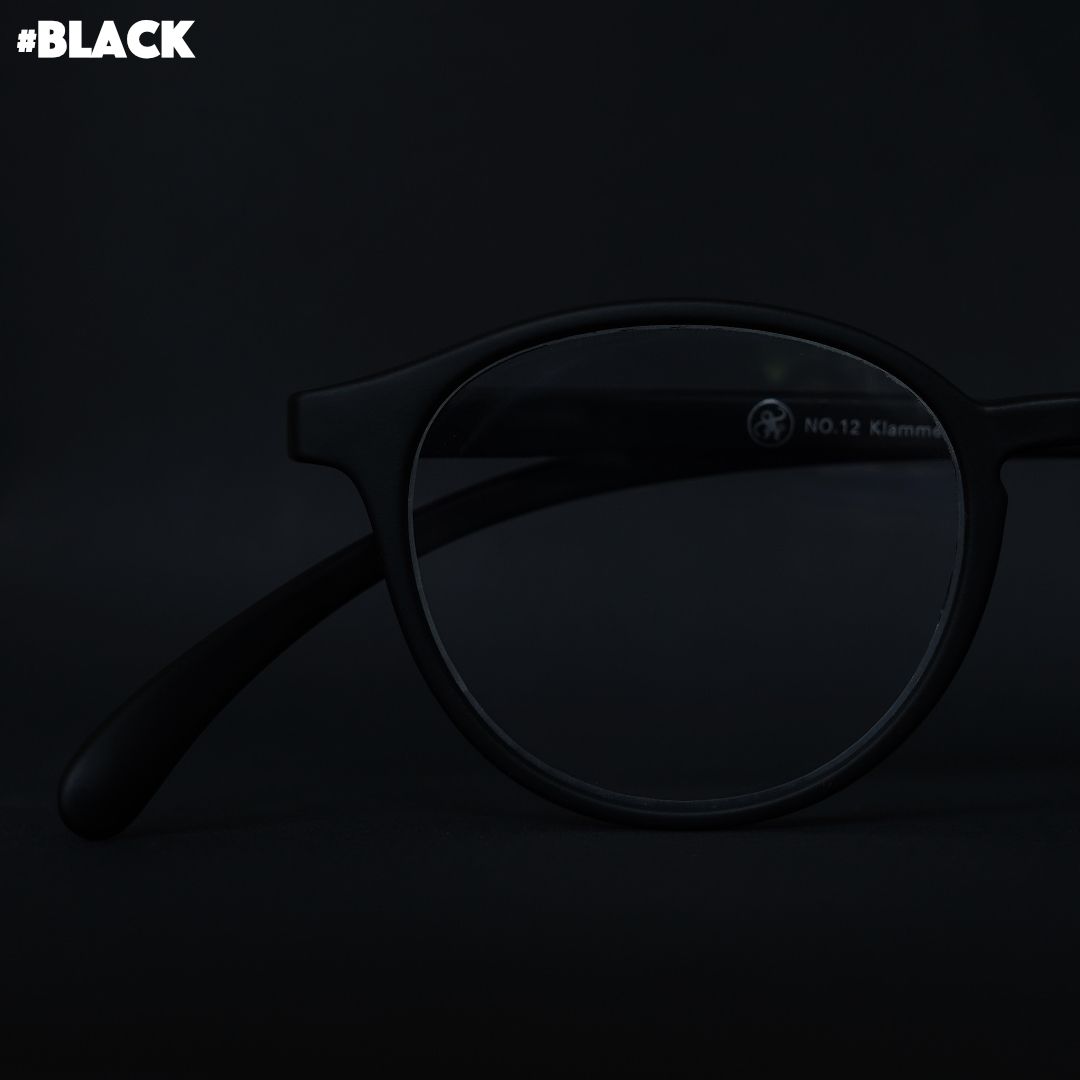 Eine schwarze Brille auf schwarzem Hintergrund.