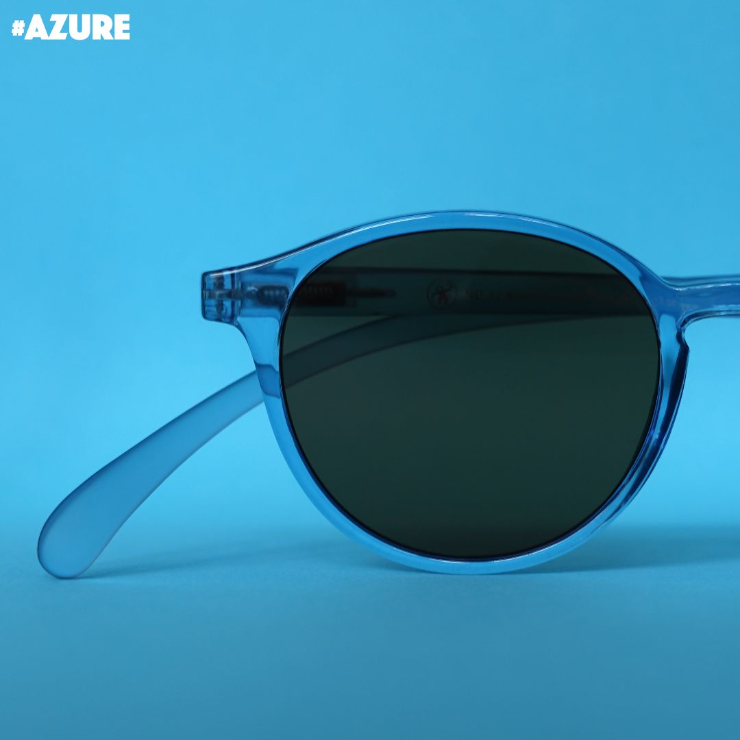 Eine azure farbene Sonnenbrille auf blauem Hintergrund.