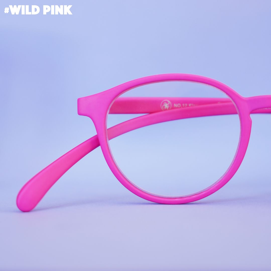 Eine pink farbene Lesebrille auf Flieder farbenem Hintergrund.