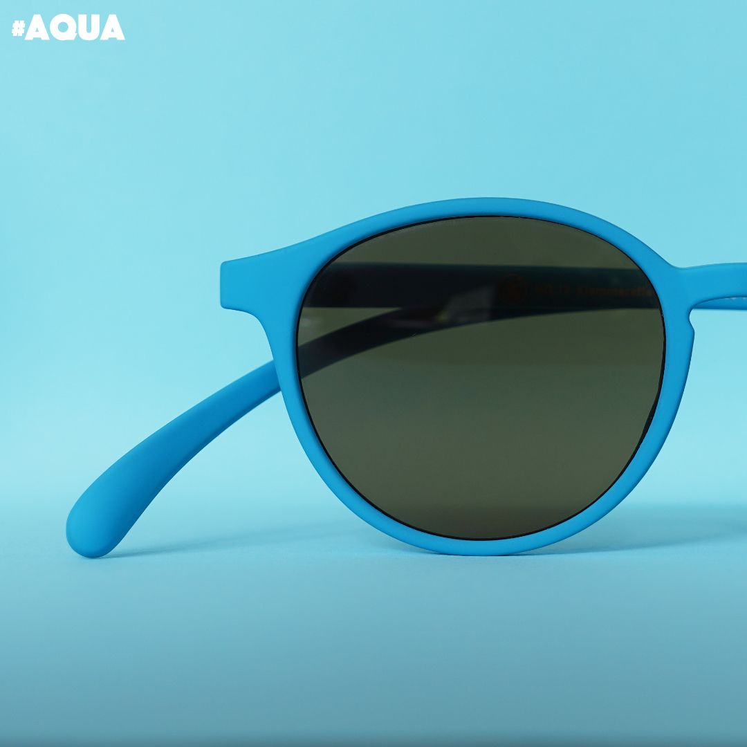 Eine aqua farbene Sonnenbrille auf blauem Hintergrund.