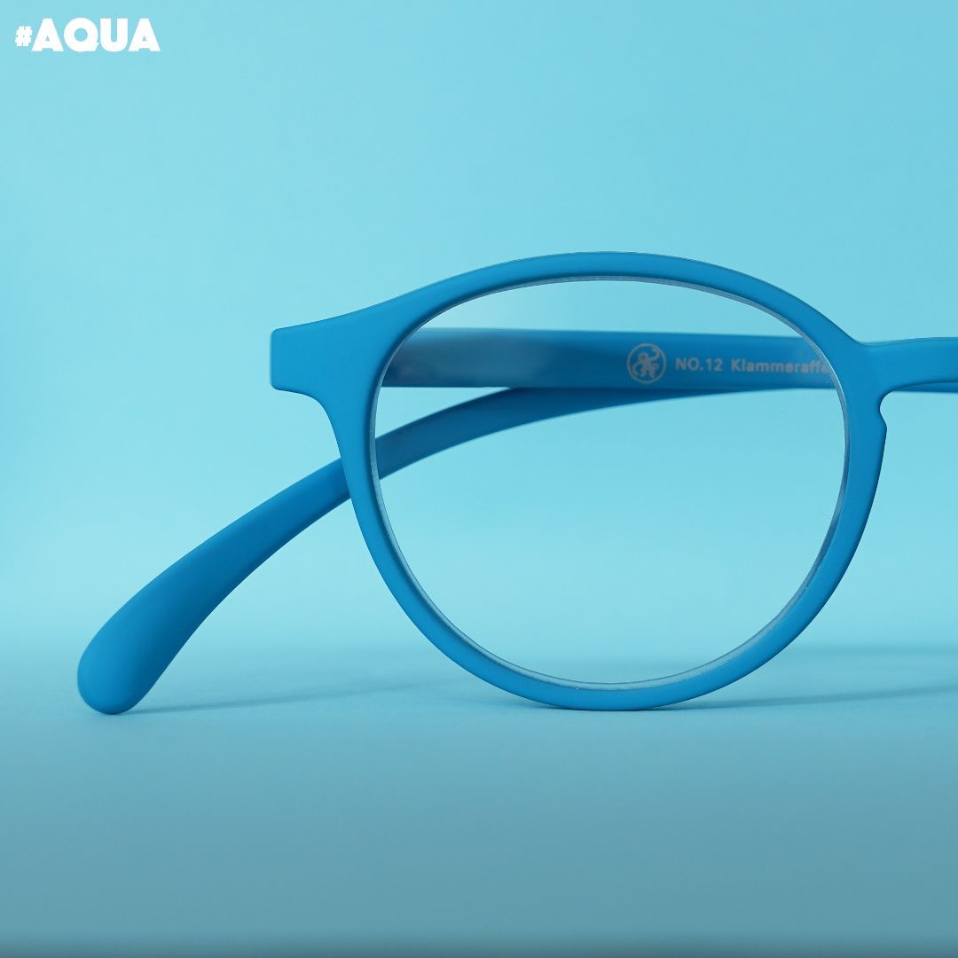 Eine aqua farbene Brille auf blauem Hintergrund.