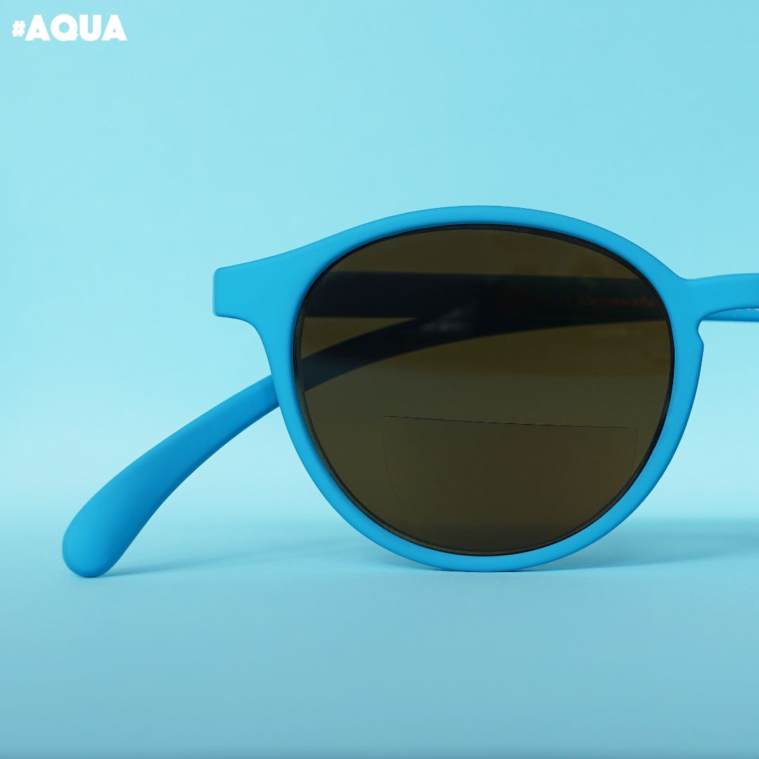 Eine aqua farbene Bifokal-Sonnenbrille auf blauem Hintergrund.