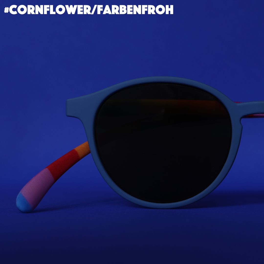 Eine blaue Bifokal-Sonnenbrille mit bunt gestreiften Bügeln auf blauem Hintergrund.