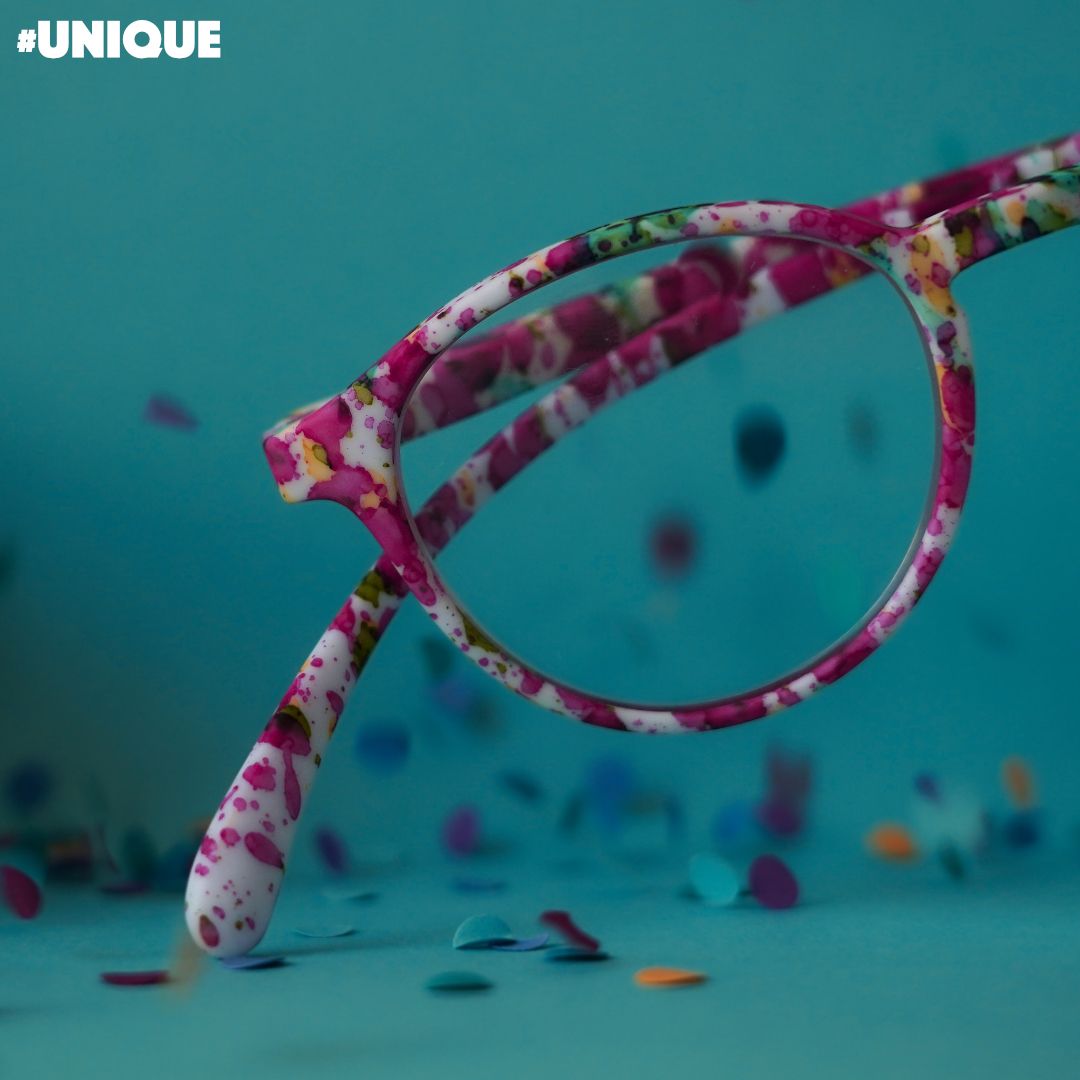 Brillen mit Blumenmuster auf türkisfarbenem Untergrund mit Konfetti; Nahaufnahme.