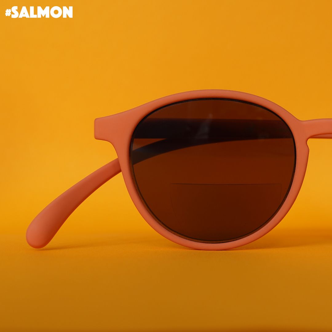 Eine orange farbene Bifokal-Sonnenbrille auf orangenem Hintergrund.