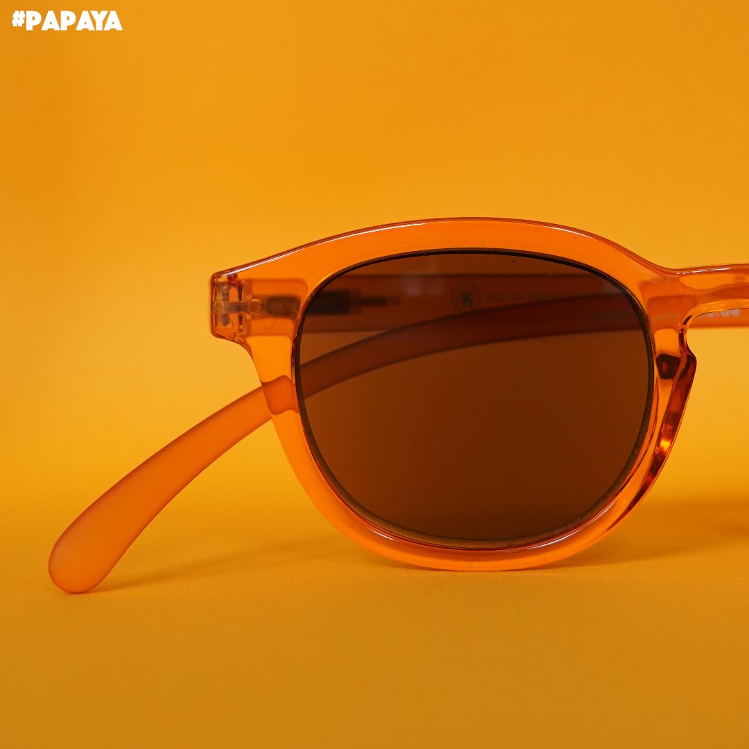 Papaya farbene Brille auf orangenem Hintergrund.