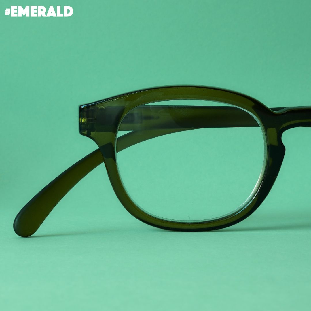 Dunkelgrüne Brille auf mint farbenem Hintergrund.