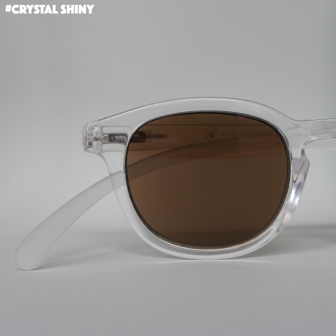 Transparent farbene Brille auf grauem Hintergrund.