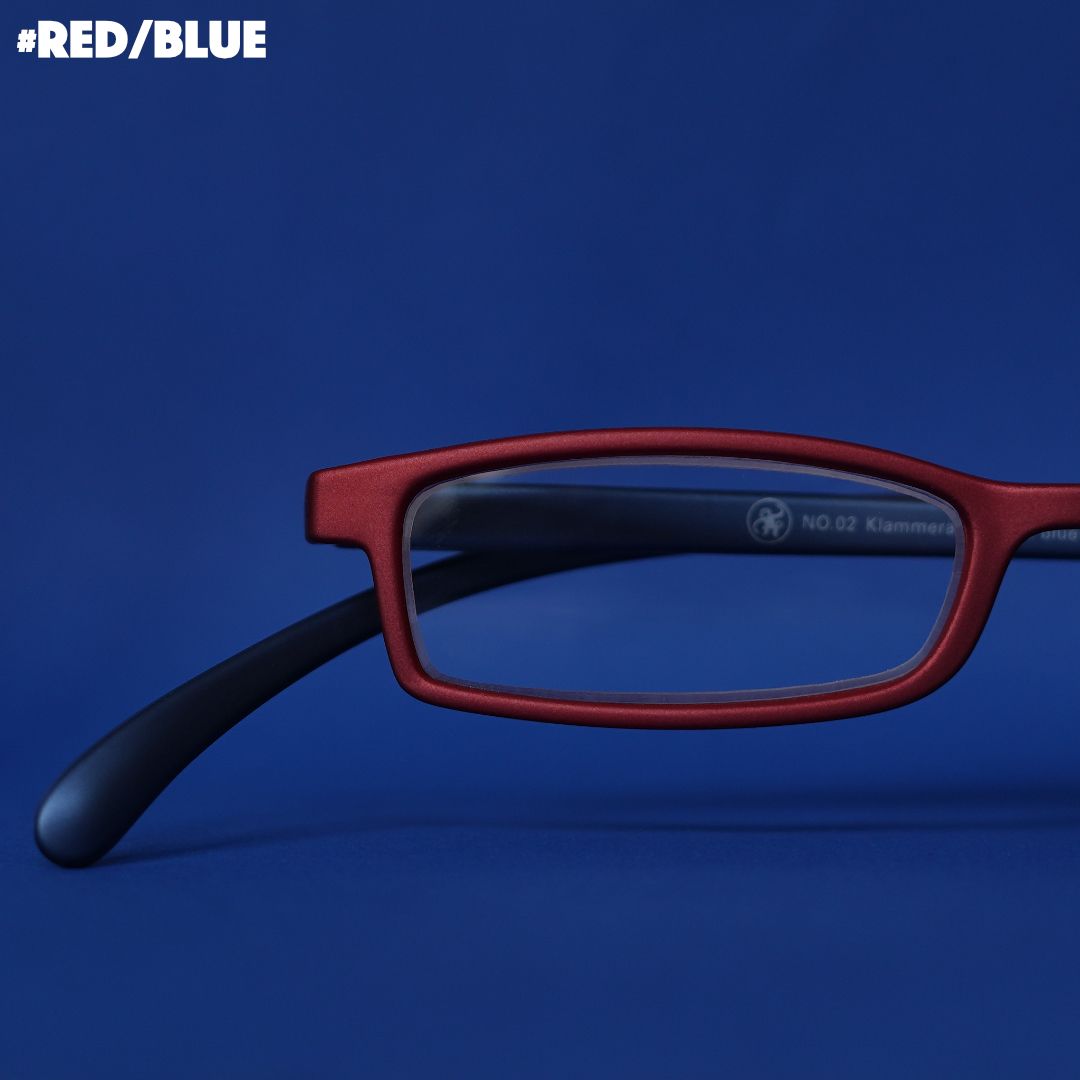 Eine rote-blaue Lesebrille auf blauem Hintergrund.
