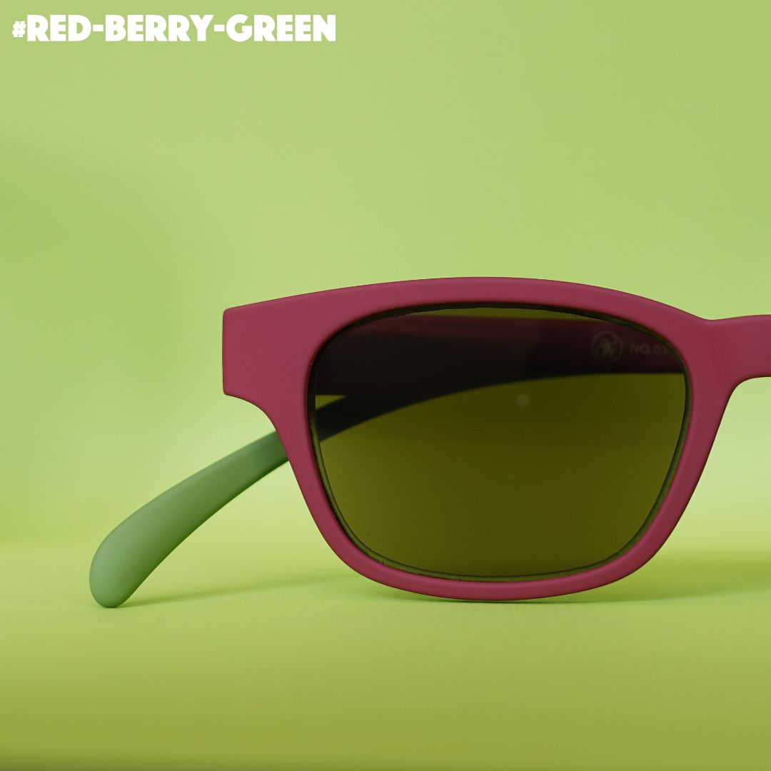 Eine rot-grün farbene Sonnenbrille auf grünem Hintergrund.