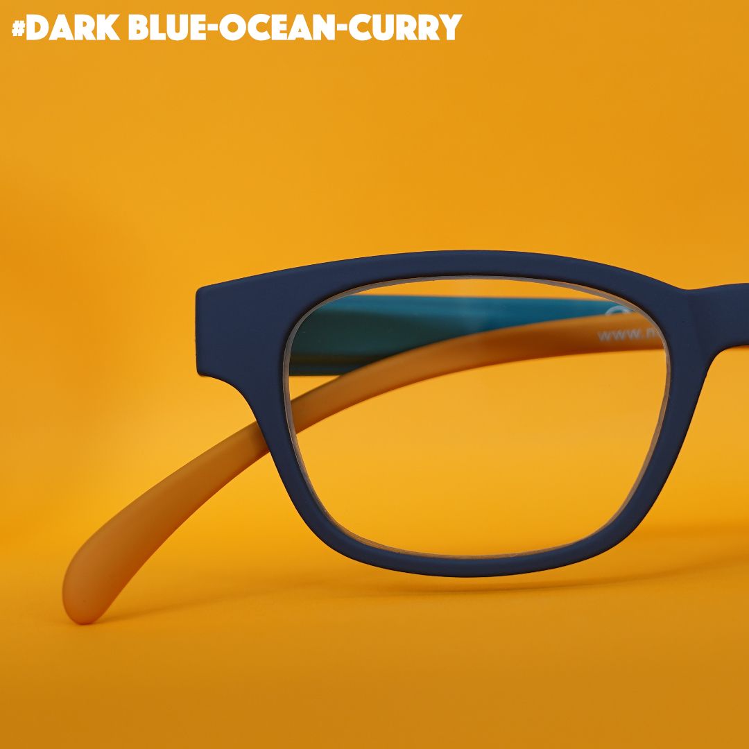 Eine dunkelblau-curry farbene Lesebrille auf orangefarbenem Hintergrund.