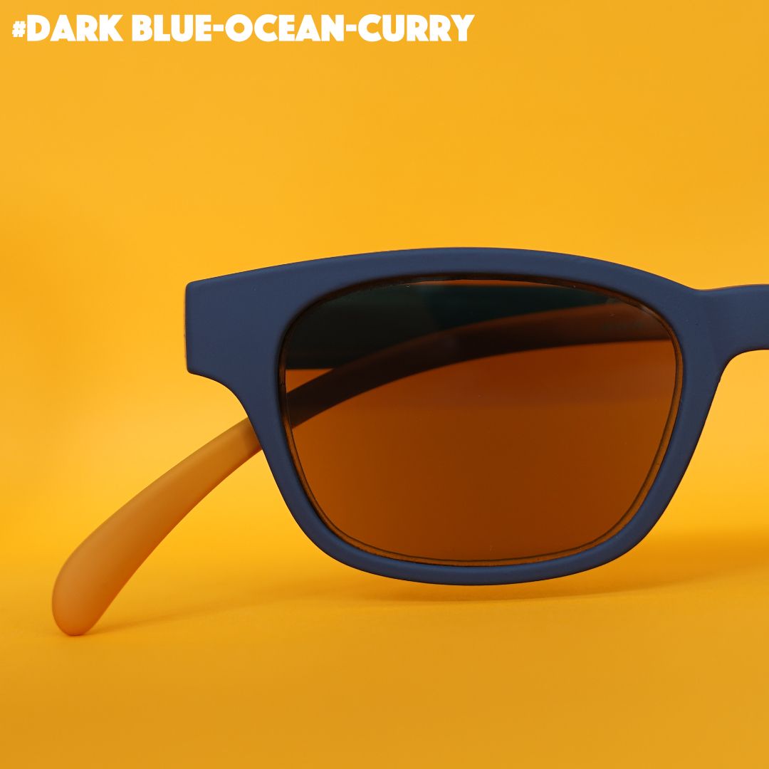 Eine dunkelblau-curry farbene Sonnenbrille auf orangenem Hintergrund.